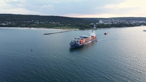Arkas, container ship cargo, Port of Varna. June, 2020. Aerial view movement of cargo ship, transports containers with goods, by sea sunset summer. Arrival of merchant ship in city seaport with crane