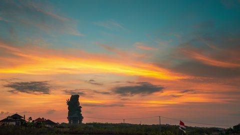 Colorful sunset over the tropical island of Bali, Indonesia with silhouette Garuda Wisnu Kencana statue. Balinese traditional symbol of hindu religion.