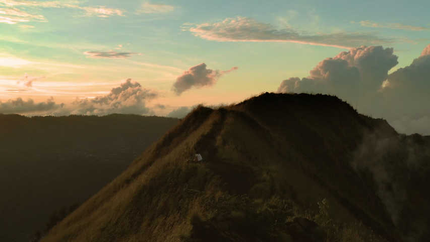 Active lifestyle woman make photo on top active volcano Mount Batur located at the center of two concentric calderas of Mount Agung on the island of Bali, Indonesia. Mount Batur Sunrise Trekking