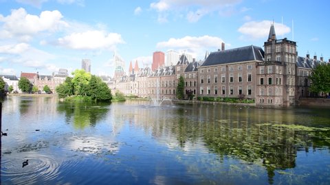 Hofvijver reflection, the Dutch parliament building with Den Haag city scape in the background and the winds blowing the pond surface creating waves under a beautiful sunny spring, Netherlands