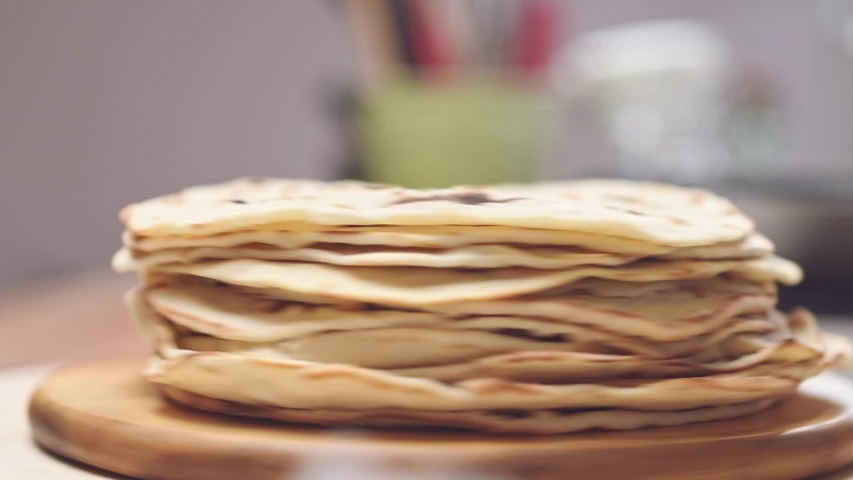 Serving of freshly baked tortillas on a wooden board. Royalty-Free Stock Footage #1056696470