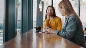 Two young women friends sitting at coffee shop having a coffee and chatting. Female friends meeting at cafe on a weekend. 
 - Powered by Shutterstock - Get 15% off with code: PIKWIZARD15