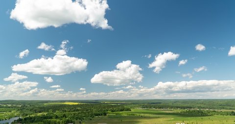 Beautiful cloudy landscape in summer time lapse. Blue sky with clouds 4K. Wonderful summer weather. The sun shines through the clouds. Clouds are floating in the sky. Loop.
