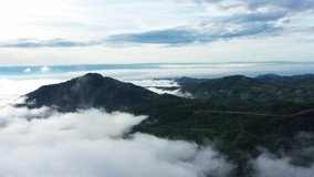 Aerial view of floating sea of clouds like cloud waves in mountains, Sea of fog, Sky above clouds, view on the mountain in the morning, 4K footage video.