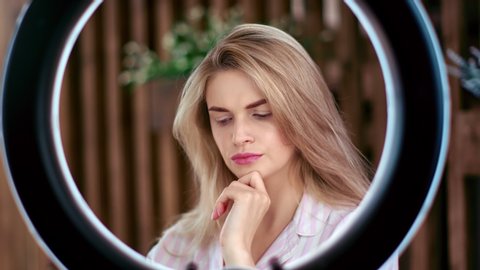 Female beauty transformation. Portrait of tired woman rotate ring lamp become fashion model. Face of pretty girl smiling and flirting demonstrate perfect makeup. Medium close up shot on 4k RED camera