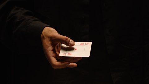 Close-up of a Magician Hand Performing Card Trick. Card Mechanic rotating heart ace card in hand . Shot on ARRI Alexa cinema camera in Slow Motion 