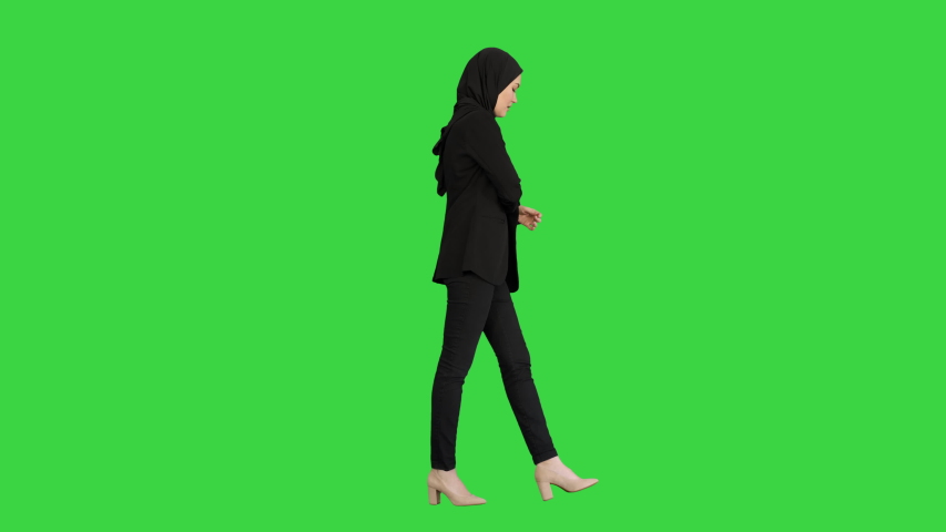 Pretty woman in hijab walking and counting money on a Green Screen, Chroma Key. | Shutterstock HD Video #1056716030