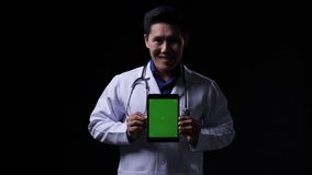 Doctor posing and looking at camera with presentation data tablet green screen. Doctor working about treatment system, prescription digital and diagnostic service. Display green screen or chroma key. - Powered by Shutterstock - Get 15% off with code: PIKWIZARD15
