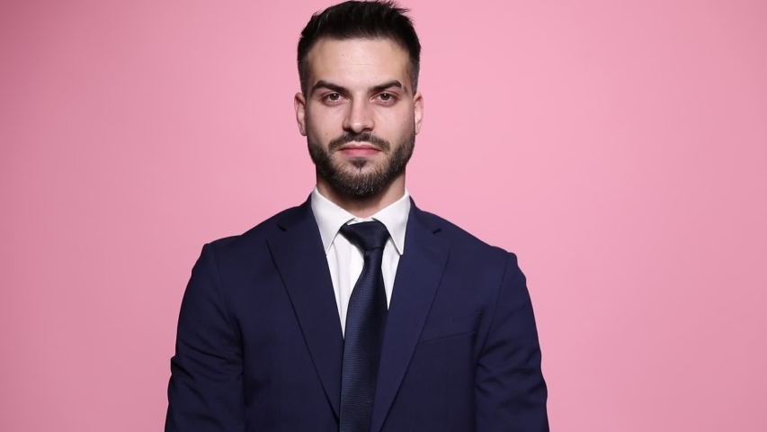 handsome businessman crossing his arms to his chest, shaking his head and listening on pink background