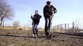 child and grandfatchild and grandfather digging shovel earth on a farm, nature  spring agriculture, 1080p videoher digging shovel earth on a farm, nature spring agriculture, 1080p video
