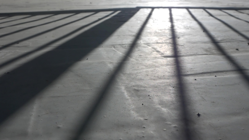 The man opens  gate, a shadow on the concrete floor. Royalty-Free Stock Footage #1056729917