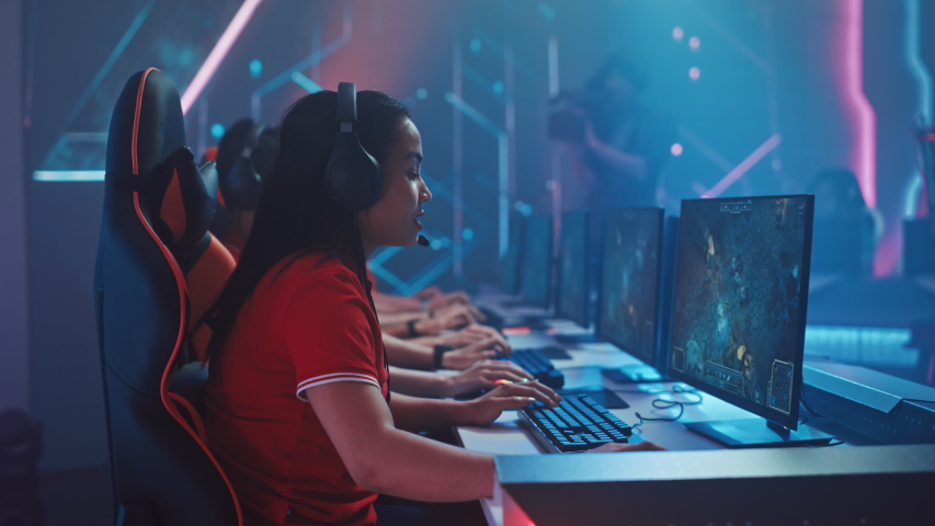Beautiful Young Female Gamer Plays Computer Video Game with Her Esports Team on a Cyber Championship. Stylish Neon Cyber Arena  Royalty-Free Stock Footage #1056734942