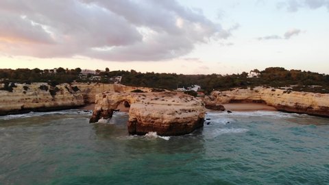 Aerial view of beautiful Praia de Benagil and sea cliffs during sunset, Algarve, Portugal. High quality 4k footage