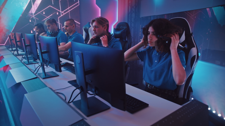 Diverse Esport Team of Pro Gamers Begin Play in Video Game on a Championship, Put on Headsets to Talk. Stylish Neon Cyber Games Arena. Online Broadcasting of Tournament Event. Elevating Crane Shot Royalty-Free Stock Footage #1056738518