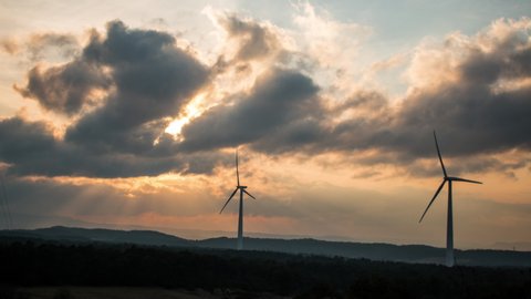 Timelapse of a power farm wind turbine spinning while sunset time.  Footage B-roll Windmill, Green Energy, Global warming, renewable energy concept 스톡 비디오