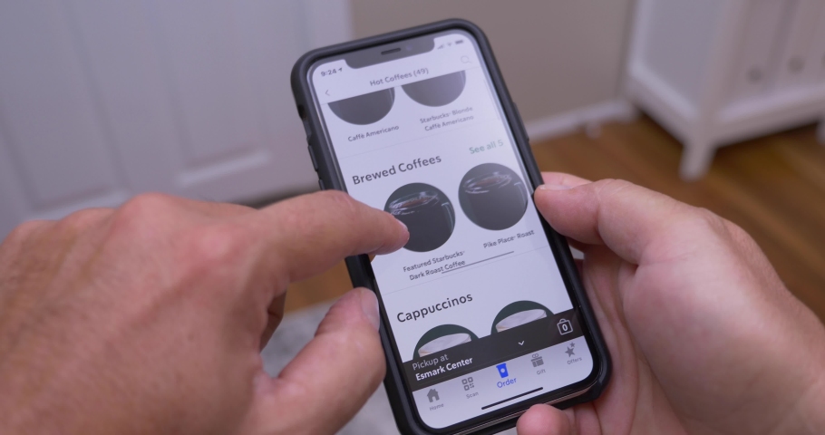 Circa July, 2020 - A man at home browses the Starbucks menu on the app on his cellphone. Contactless ordering became a common practice during the COVID-19 pandemic of 2020.  	 | Shutterstock HD Video #1056744155