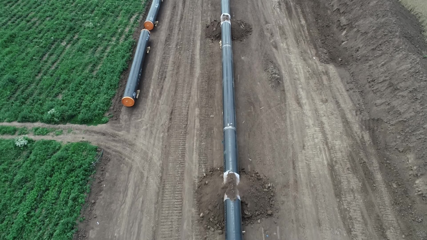 Aerial view of gas and oil pipeline construction. Pipes welded together. Big pipeline is under construction. Royalty-Free Stock Footage #1056744899
