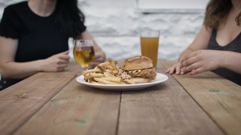 Restaurants are open. Friends get together for first time in a long time on a brewpub patio. Eating and drinking during social distancing. Shot in slow-motion and in 4k. 