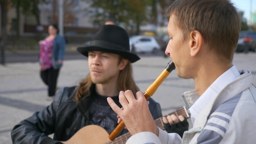Young Woman Listens Street Musicians Playing Music at City Square