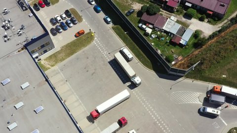 Aerial Shot of Industrial Warehouse Loading Dock where Many Truck with Semi Trailers Load Merchandise.