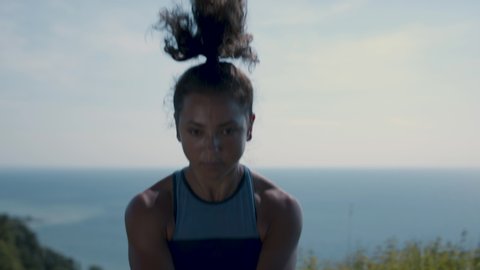 Powerful woman exercises on hilltop in order to achieve her goals. Focused and determined. Shot in 4k. 