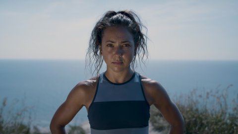 Portrait of a powerful and confident woman standing on a cliff's edge. Full of pride after achieving her goals. Shot in 4k. 