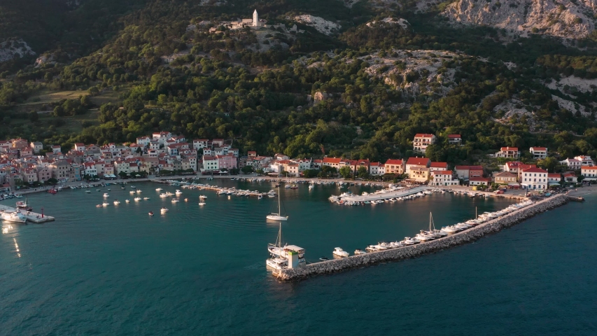 Flying Over The Island Of Krk In Croatia On A Summer Day. Boats And Yachts Moored By The Coast With Beautiful Villas On A Sunny Morning - aerial