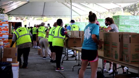Pompano Beach, Florida, USA - July 30, 2020: Food Distribution with Pompano Beach BSO officers and Pompano Beach Fire Department, volunteers at Pompano Beach Mall parking lot, footage