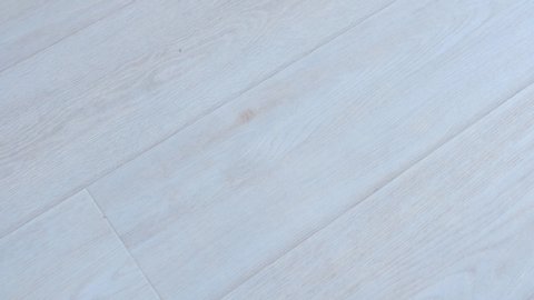 Light grey linoleum surface on floor with wooden pattern in modern interior. Camera in motion. Looks like laminate. Wooden texture, modern material for renovation.