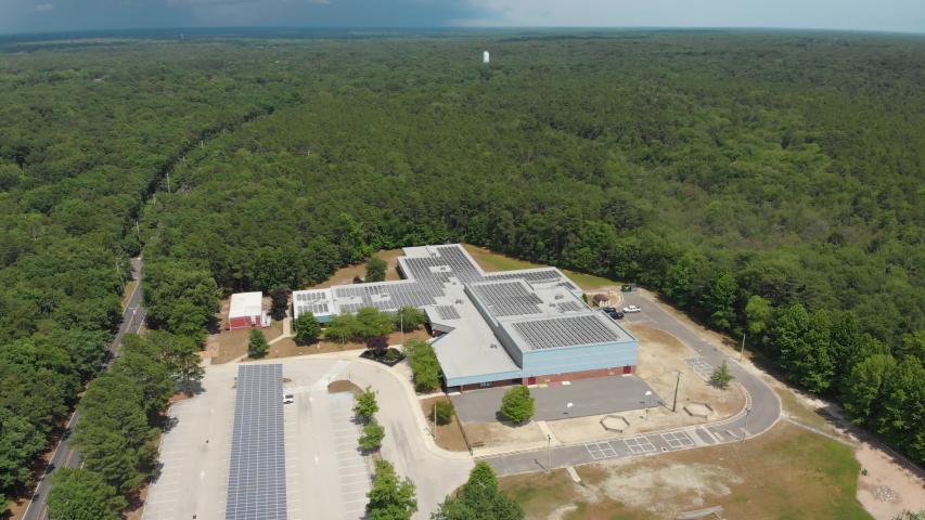 Factory building with solar heating panels. Aerial circle pan