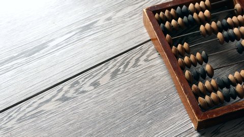 A Elderly Man Moves Wooden Knuckles On A Outdated Vintage Wooden Abacus On A Gray Desk Panning Slider Shot, Close-up. Natural Daylight..