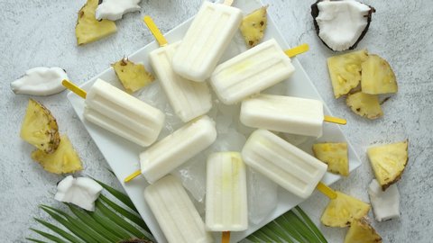 Homemade vegan popsicles made with coconut milk and pineapple. Delicious healthy summer snack. Top view, flat lay.