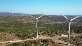 Wind Turbines Spinning. This aerial stock video features turbines in a wind farm in a mountain landscape.