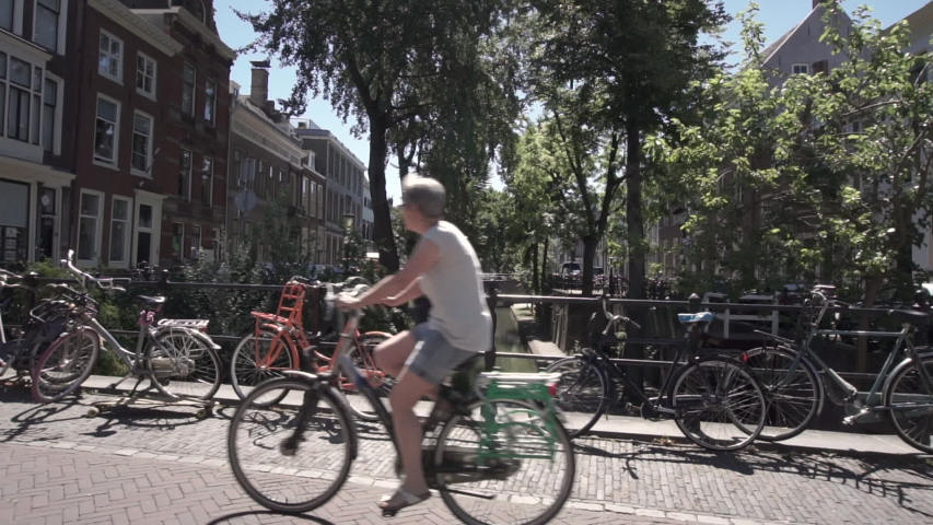 Utrecht, The Netherlands. View of one of the back canals overlooked by mansions. Bikes on the bridge. Slow forward motion 