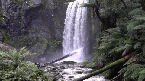 Waterfall flowing into rocky river stream in Australian rainforest