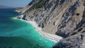 Aerial drone video of famous turquoise Aegean sea beach of Lalaria , featuring iconic rocky arch on a windy morning, Skiathos island, Sporades, Greece