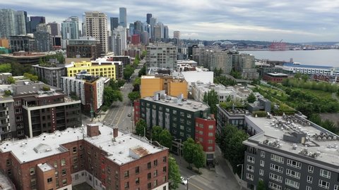 Aerial / drone footage of the Seattle waterfront, Belltown, Elliott Bay, Puget Sound streets without people downtown, in the commercial district of Seattle, Washington during the pandemic