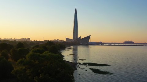Lakhta Center Skyscraper , Gulf of Finland Shore and Saint-Petersburg City at Sunrise. Aerial View. Saint-Petersburg, Russia. Drone Flies Forward and Upwards. Reveal Shot