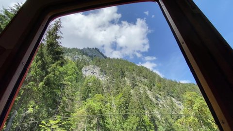Beautiful view of mountain and trees through train window at Alpnachstad, Switzerland. High quality 4k footage
