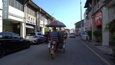 George Town, Penang / Malaysia - Jan 24 2020: Gimbal shot trishaws driver bring tourist tourist spot at George Town.