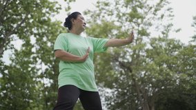 Asian overweight baby boom aged woman doing Chinese martial arts tai chi at the park, senior old age exercise healthy life, slow movement, relax calm meditation, mind body and nature synchronize - Powered by Shutterstock - Get 15% off with code: PIKWIZARD15