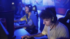 Excited professional cyber sport gamers playing in online video game. Overjoyed young men winning video game having fun together give high five celebrating victory
