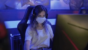 Concentrated woman in face masks plays in Video Games in Modern computer club.