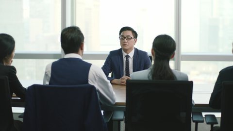 young asian business man being interviewed by a group of hr executives