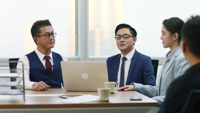 asian boss introducing new team member to colleagues and coworkers during staff meeting in modern office Royalty-Free Stock Footage #1056846530