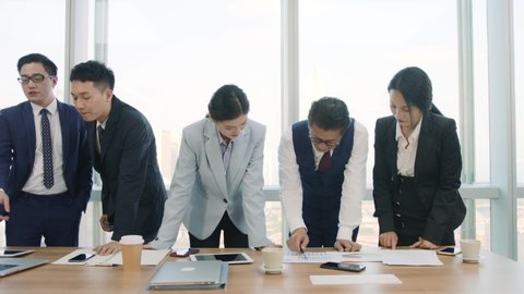 team of asian businesspeople meeting in company conference room discussing business plan