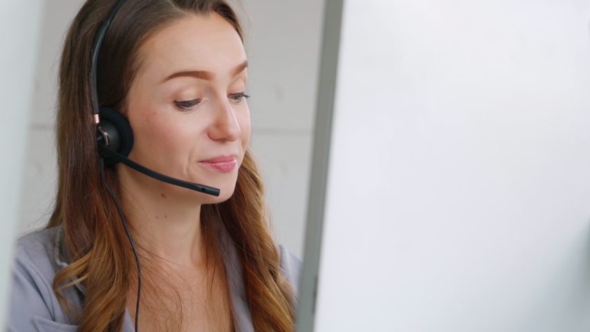 Business people wearing headset working in office to support remote customer or colleague. Call center, telemarketing, customer support agent provide service on telephone video conference call. Royalty-Free Stock Footage #1056850295