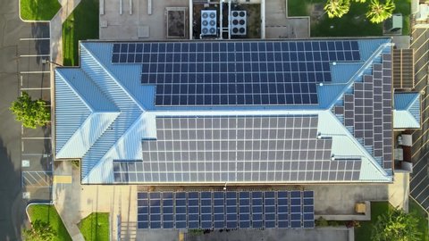 Solar panels on factory roof. Generating clean renewable electric energy. Drone aerial shot 4k. Sustainable building in America.