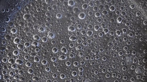 Macro abstract background. Water is almost boiling. Hot water for cooking dumplings in a pan. Bubbles of steam inside boiling water.
