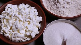 Soft cottage cheese,wheat flour,white sugar prepared for cooking in restaurant kitchen.Uncooked natural ingredients filmed in close up video clip